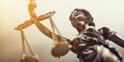 Bronze Lady Justice statue holding scales, symbol of law and fairness.