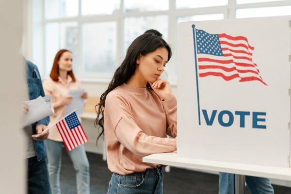Pensive,Young,Woman,,Asian,Voter,Waiting,In,Line,,Standing,In