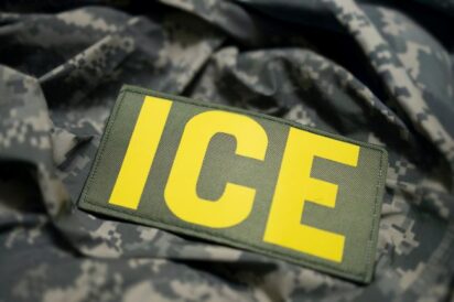 ICE patch on camouflage uniform indicating Immigration and Customs Enforcement.